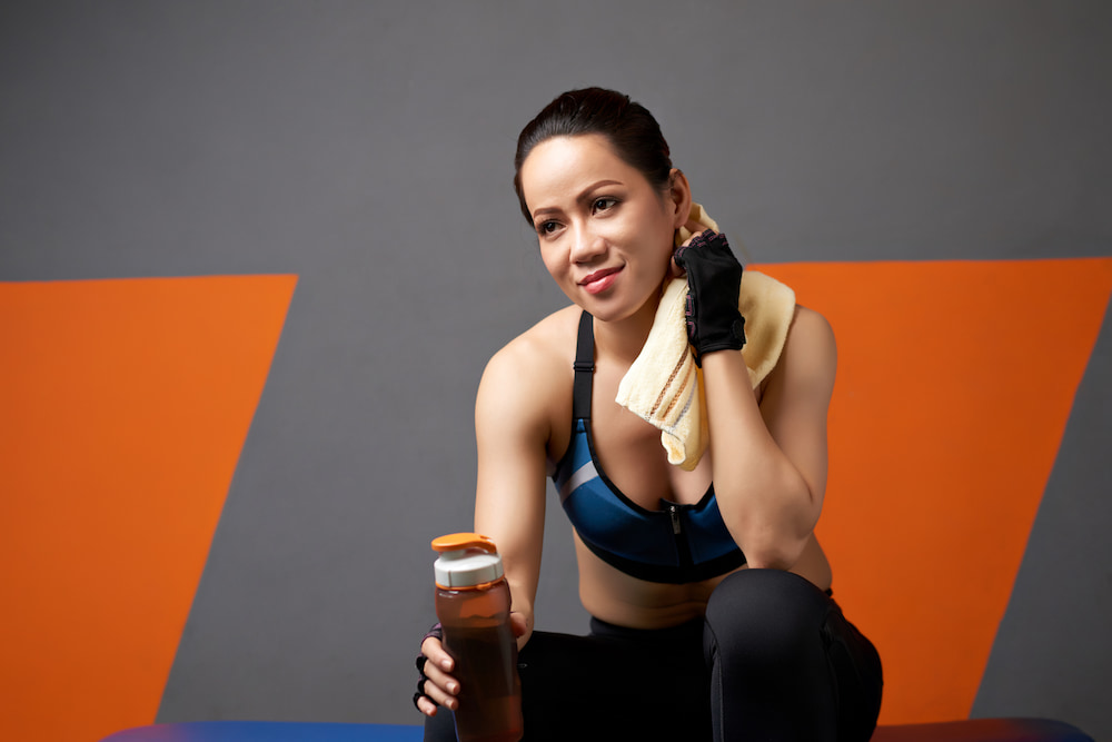 mujer tomando un batido después de entrenar