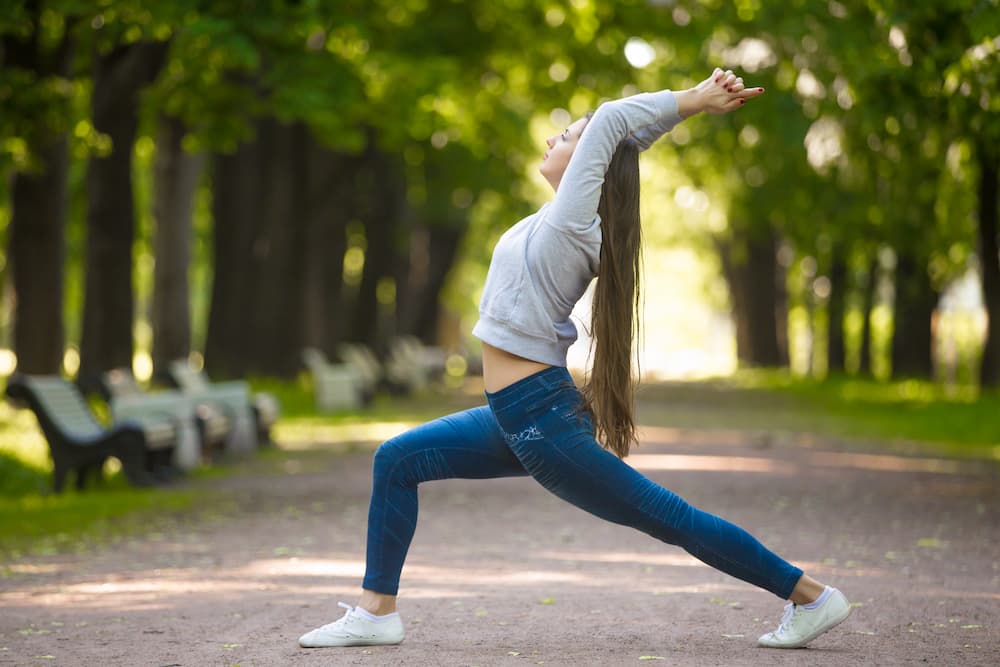 mujer realizando un estiramiento al aire libre