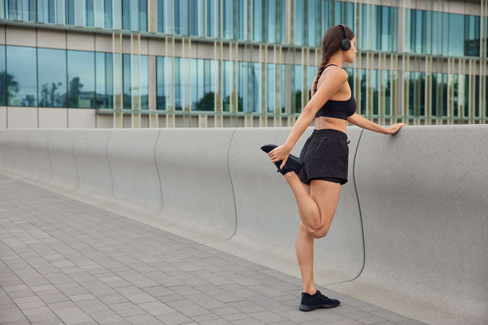 mujer realizando estiramiento de cuádriceps