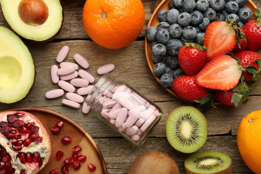 Frasco de multivitamínicos junto a alimentos saludables